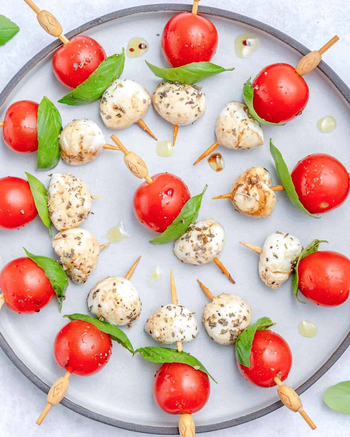 mini caprese skewers served on a round plate.