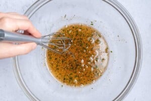 whisking the shrimp marinade in a bowl