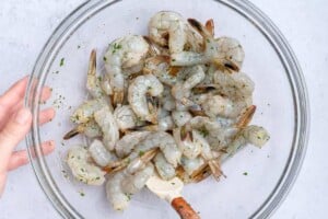mixing the shrimp in the marinade in the bowl.