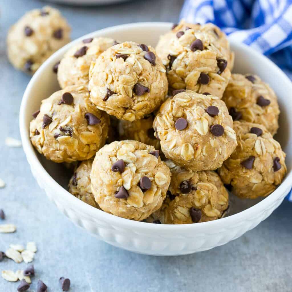 side shot of a white bowl with peanut butter and oats energy balls