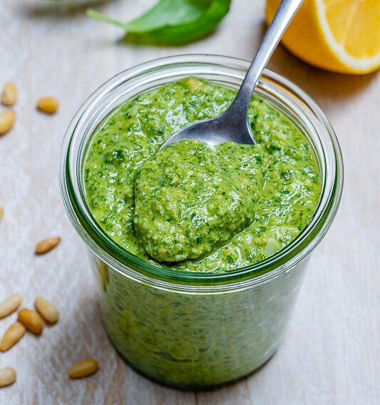 jar of pesto with a spoon in a jar with homemade pesto