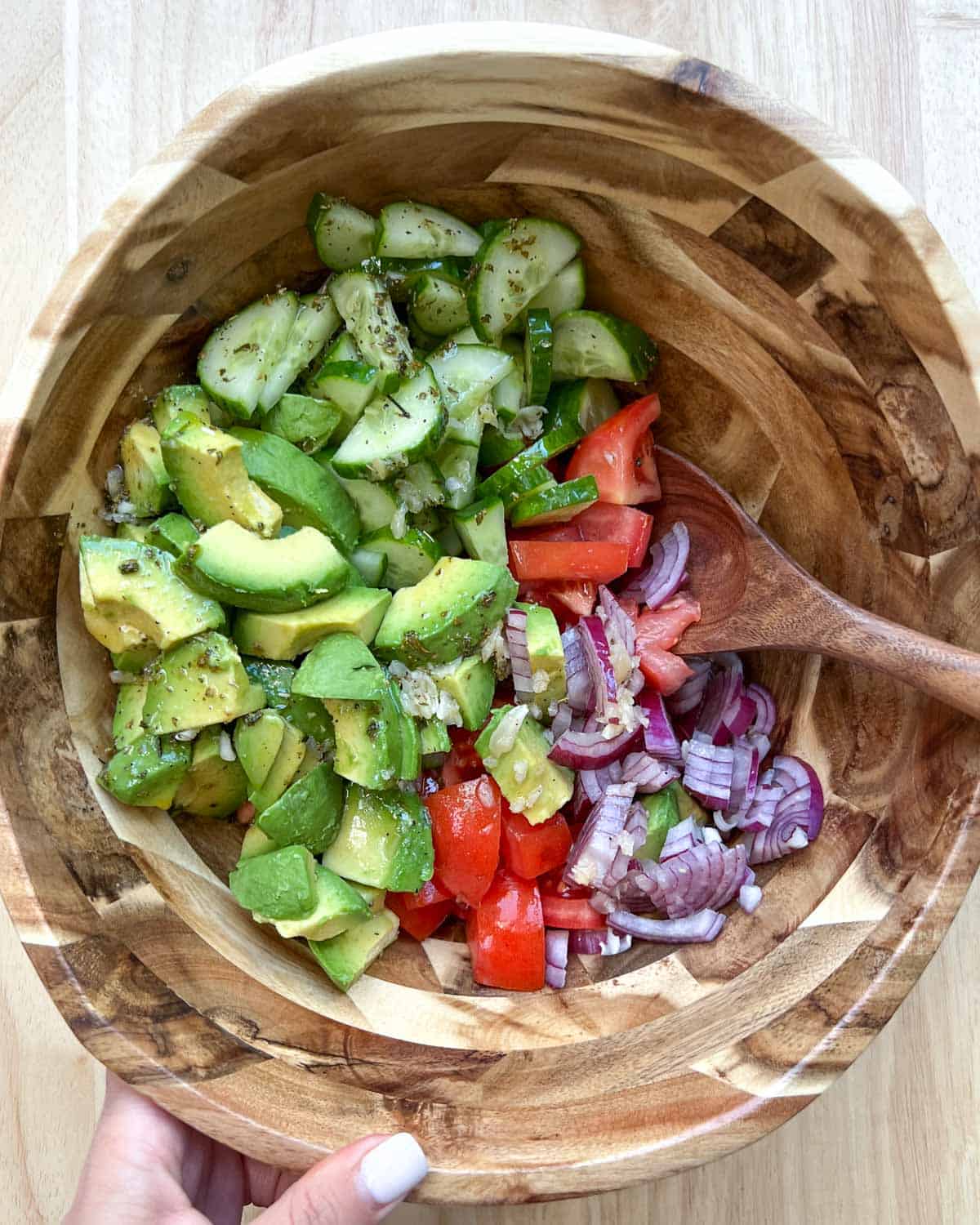 Wooden spoon in salad bowl before mixing.