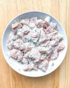 Marinating chicken breast bites on a plate.