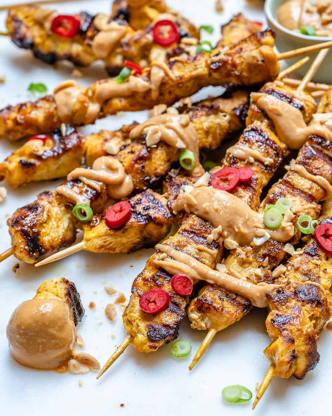 side shot of chicken satay skewers with peanut sauce