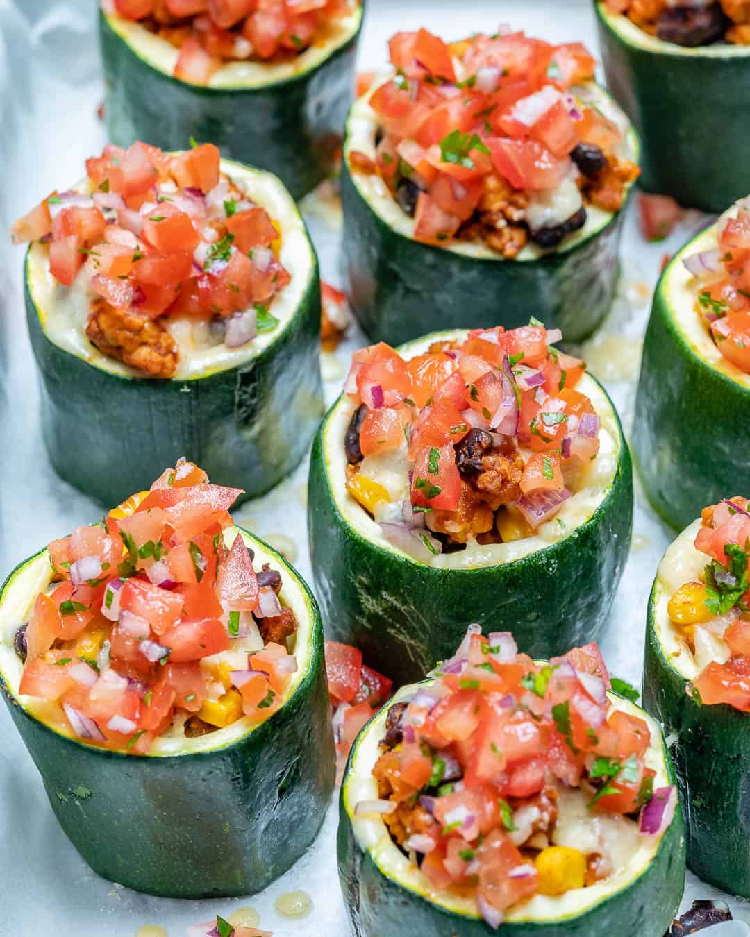 small zucchini cups stuffed with a meat mixture and chopped tomatoes.