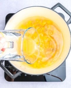 adding water to the corn corn soup ingredients in the pot.