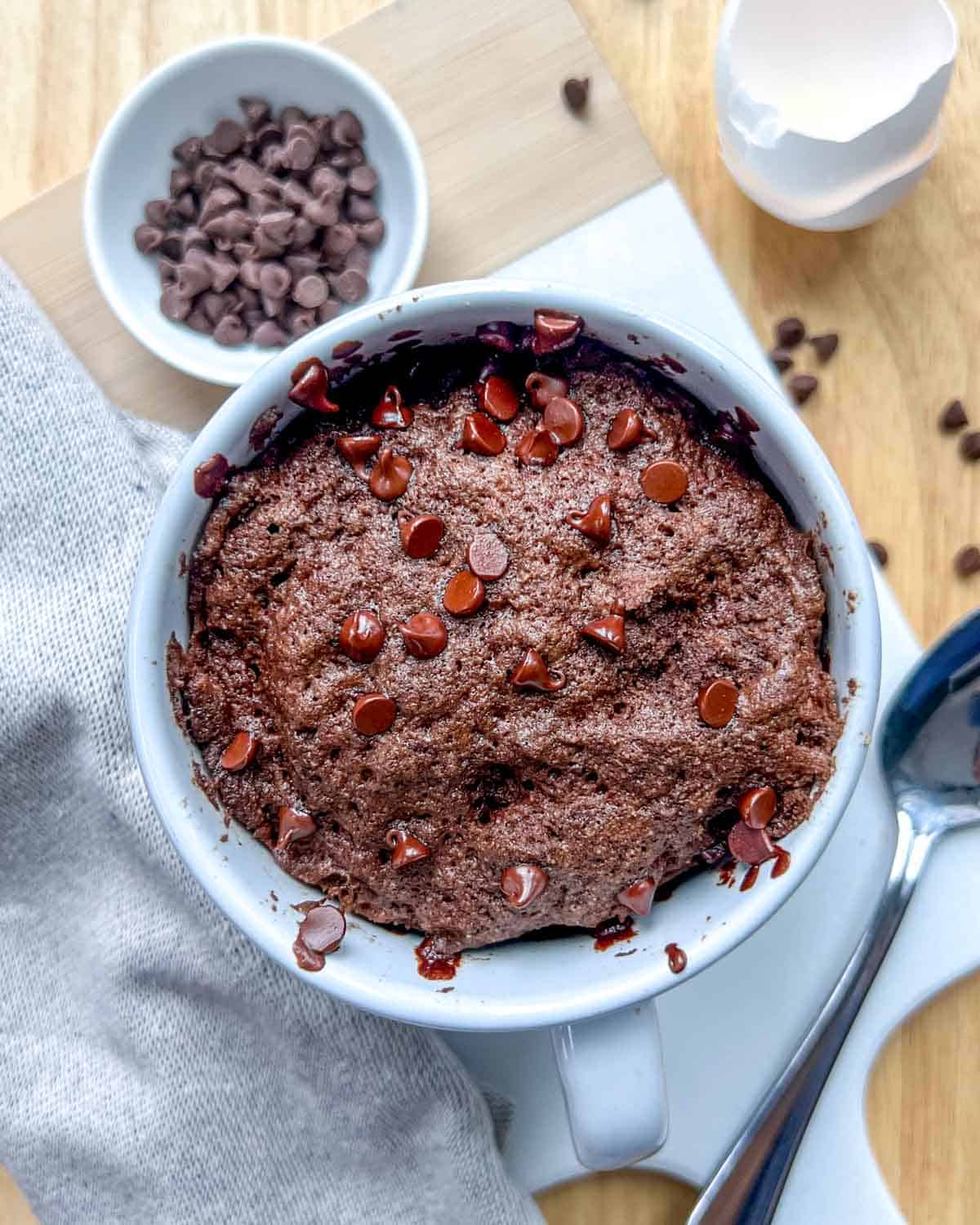 chocolate cake in a mug topped with chocolate chips.