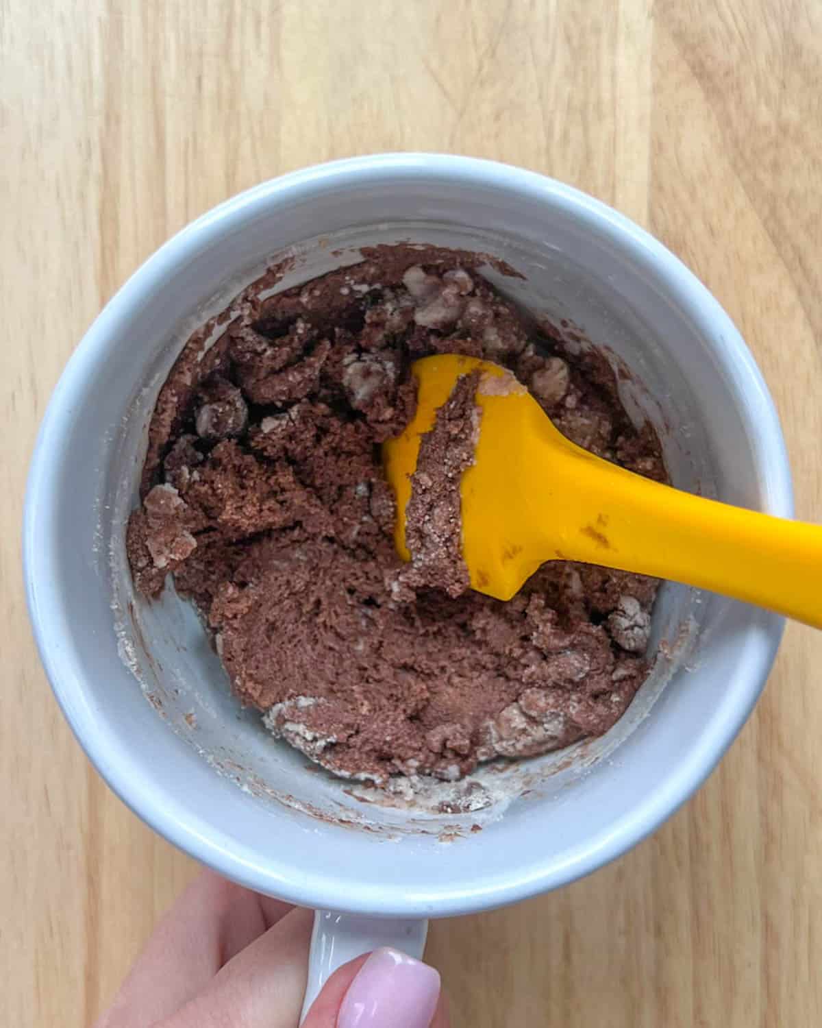 yellow spatula mixing chocolate with the flour and protein powder.