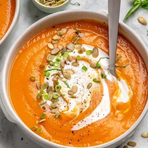 easy pumpkin soup in a white bowl with a spoon in the bowl