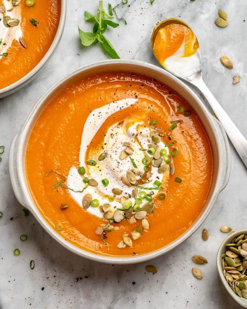 vegan soup recipe with pumpkin and a spoon to the side 