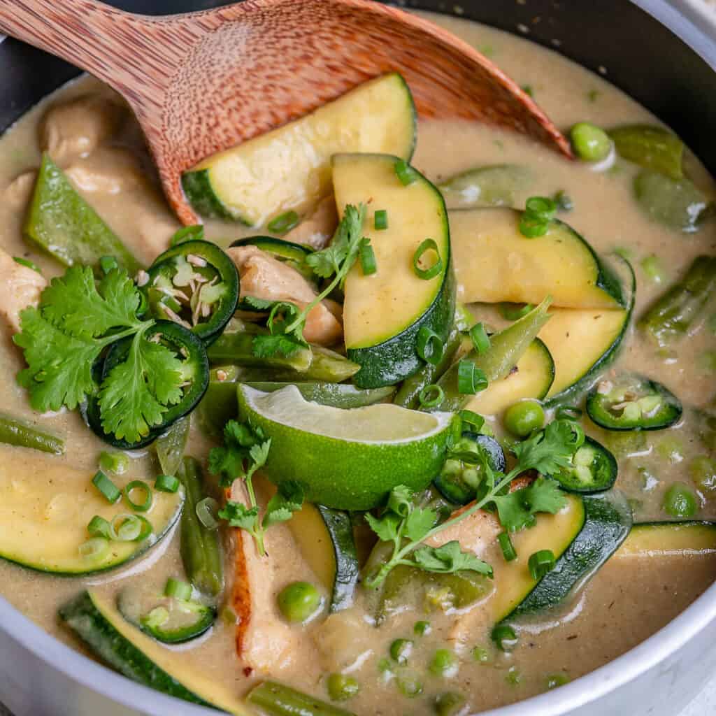 close wooden spoon in chicken green colored curry recipe