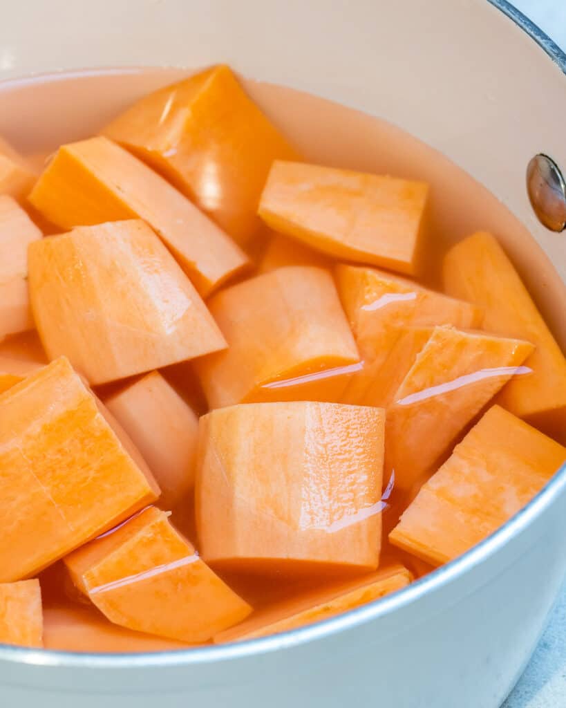 chopped sweet potatoes in a bowl full of water