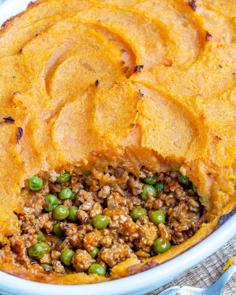 close up view of a portion take off sweet potato shepherd's pie from a dish 