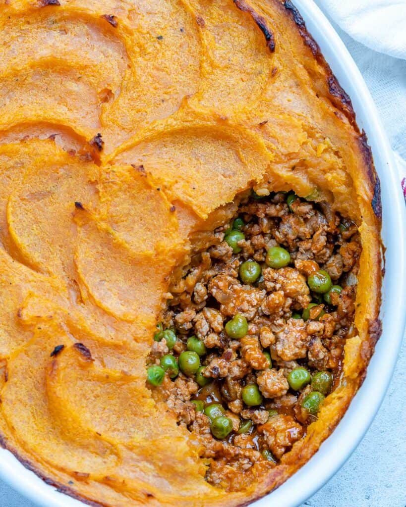 top view up view of a sweet potato shepherd's pie in a dish with a portion taken off