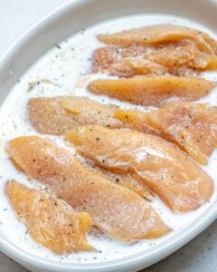 chicken tenders added in a bowl with marinade tenders recipe