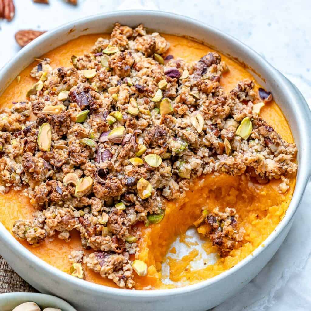 side shot of sweet potato casserole in a dish with a portion taken out