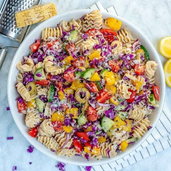 a bowl of pasta salad loaded with veggies and tossed in dressing.