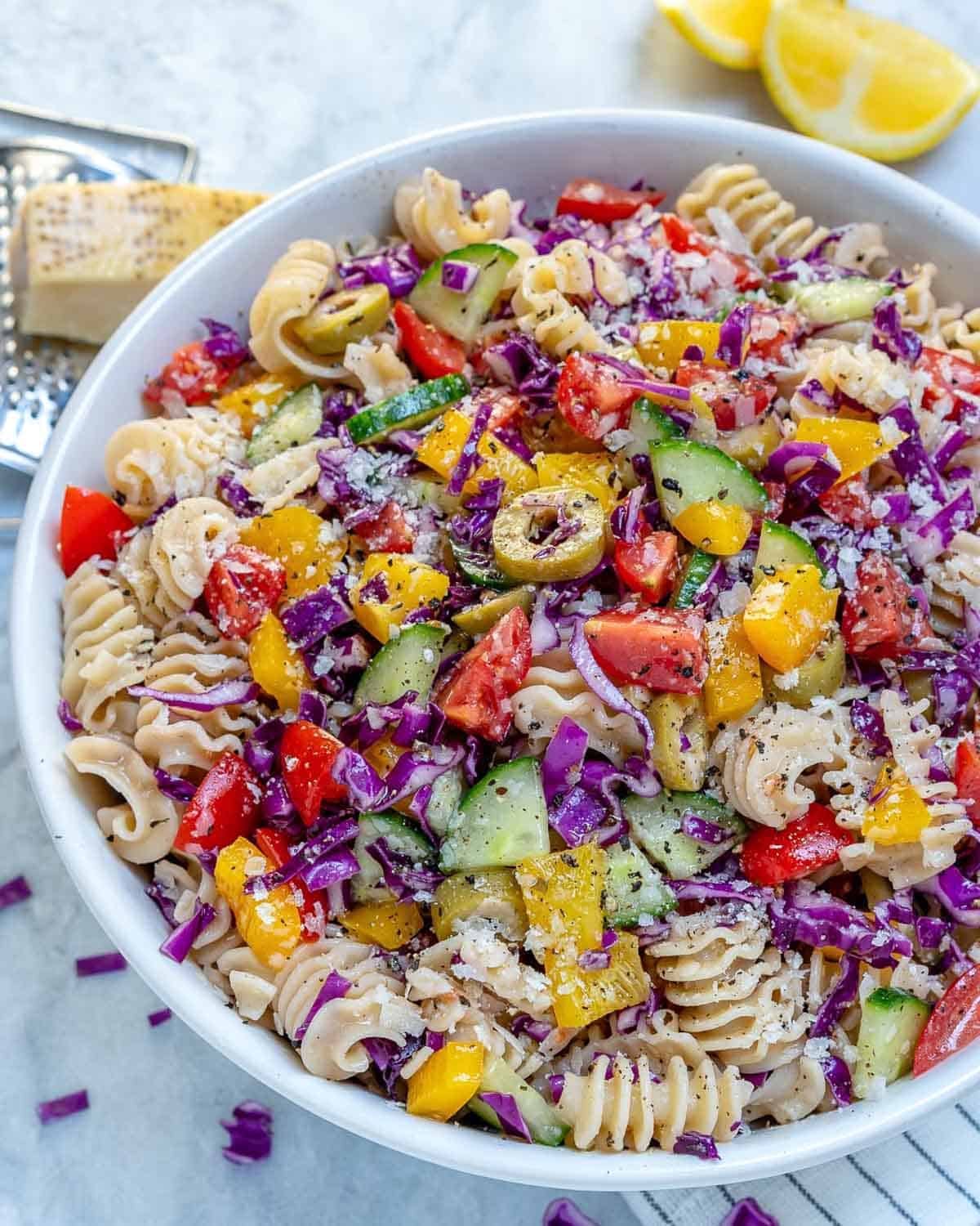 a bowl filled with pasta salad and veggies mixed in with dressing.