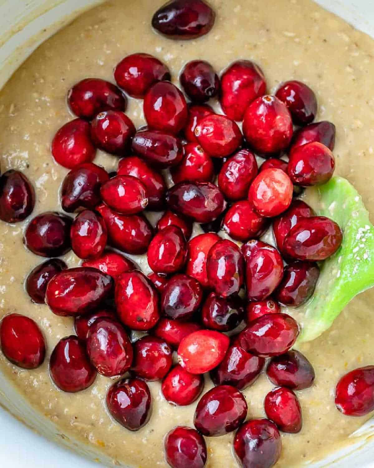 cranberry added to the bread batter in a bowl.