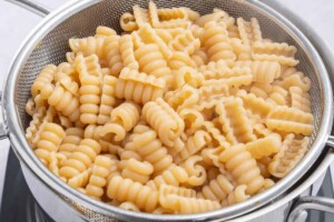 Cooked pasta in a steaming basket.