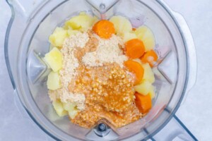 ingredients for mac and cheese sauce added to a blender.