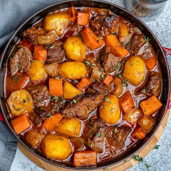 a black skillet with beef stew made with carrots and potatoes.