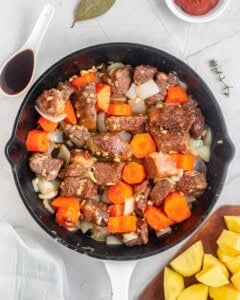 stew ingredients tossed together and sauteed in a skillet.