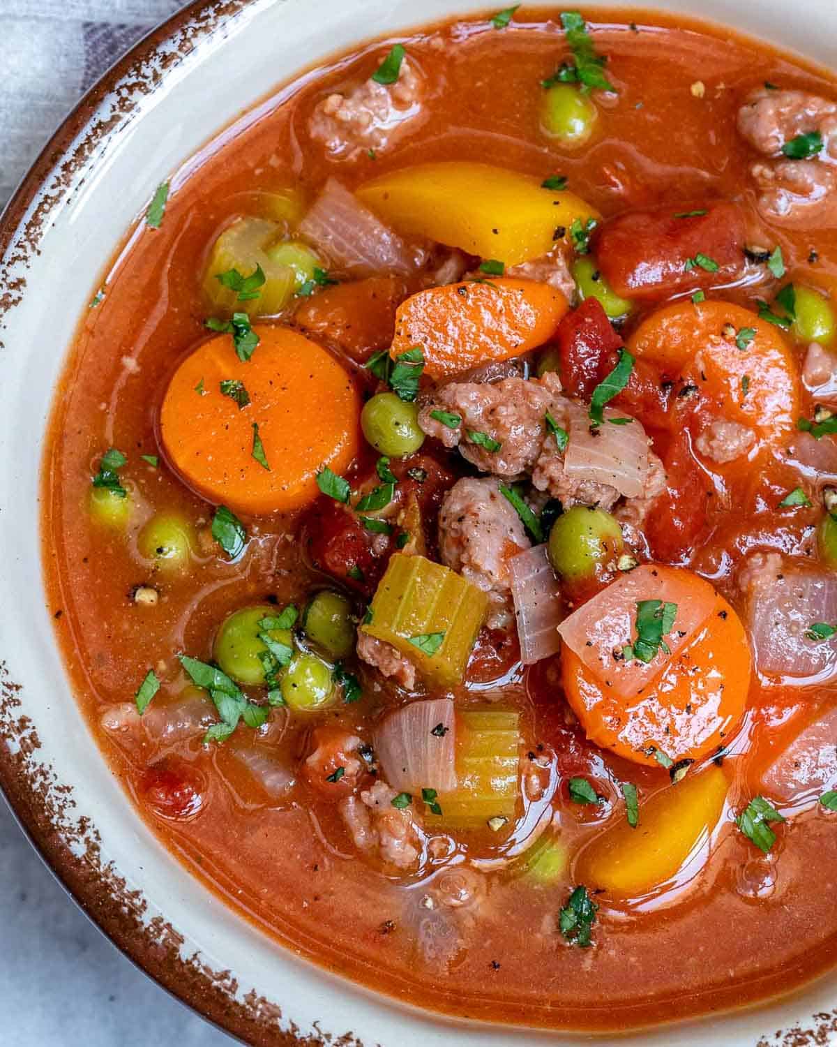 a bowl of hamburger soup with potatoes and veggies.