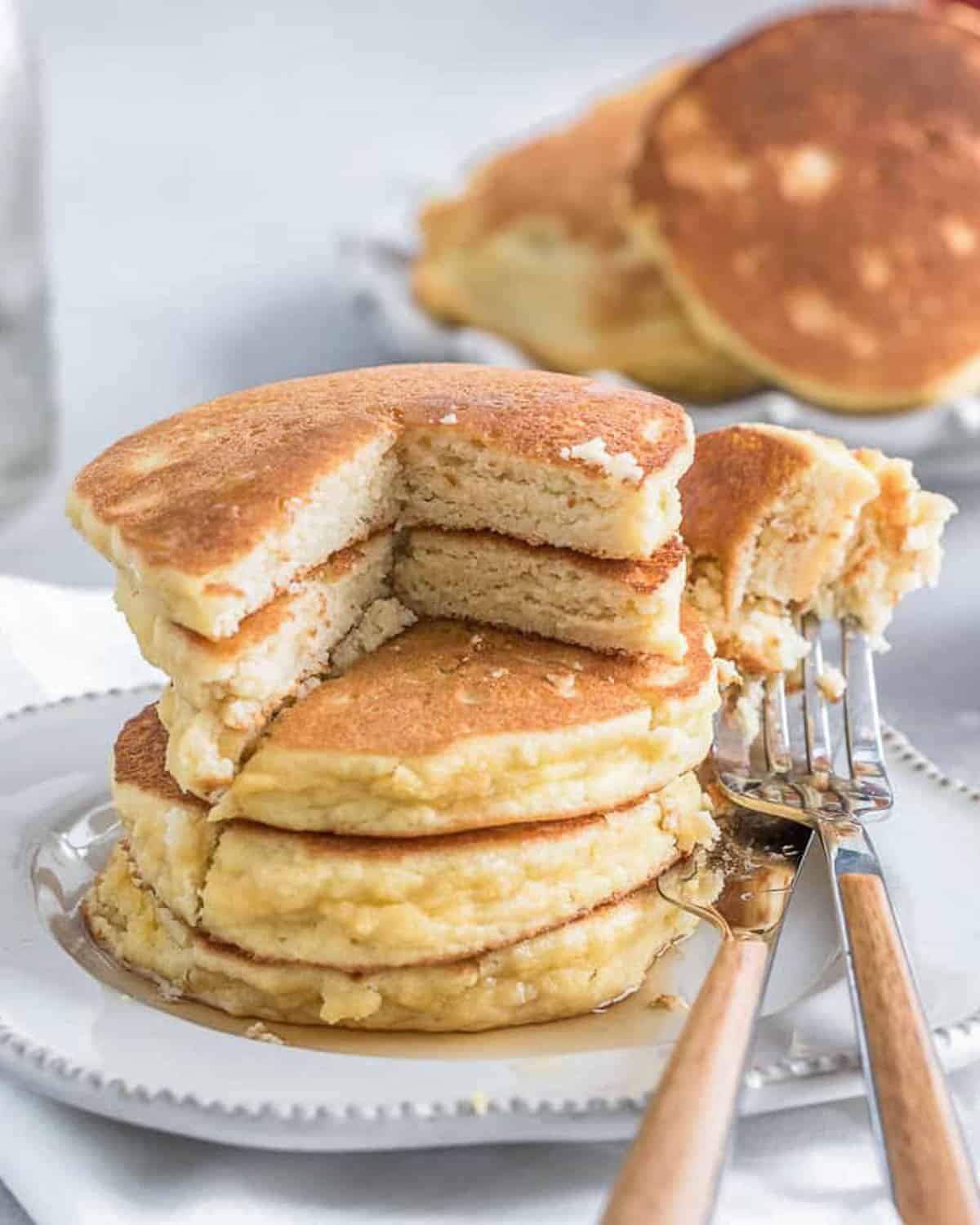 bites taken off pancake on a plate.