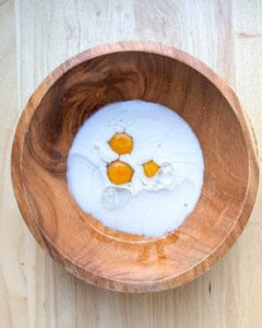 a bowl with eggs, milk, and oil.