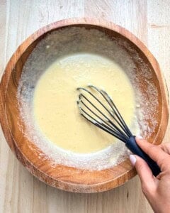 Batter for pancakes mixed into a bowl.