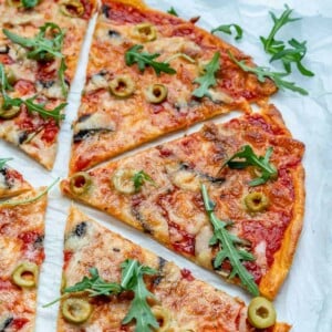 close up thin-crust pizza slices on a parchment paper