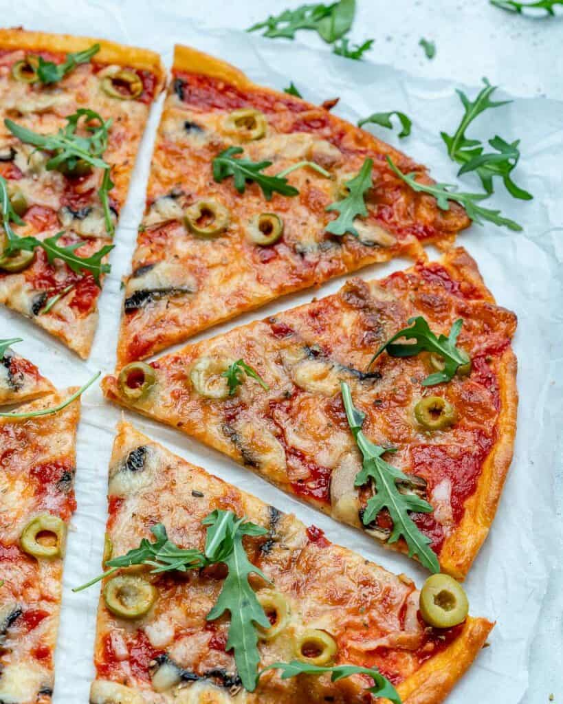 close up thin-crust pizza slices on a parchment paper 
