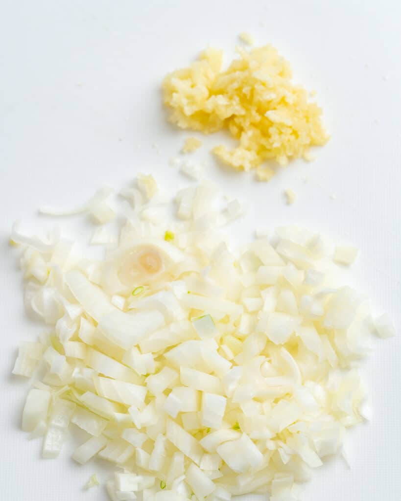 Diced onion and garlic on cutting board.
