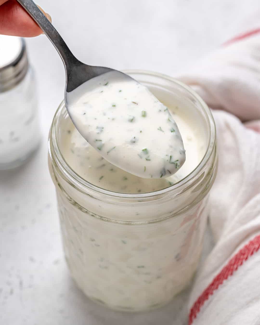 Spoon of homemade ranch dressing in jar