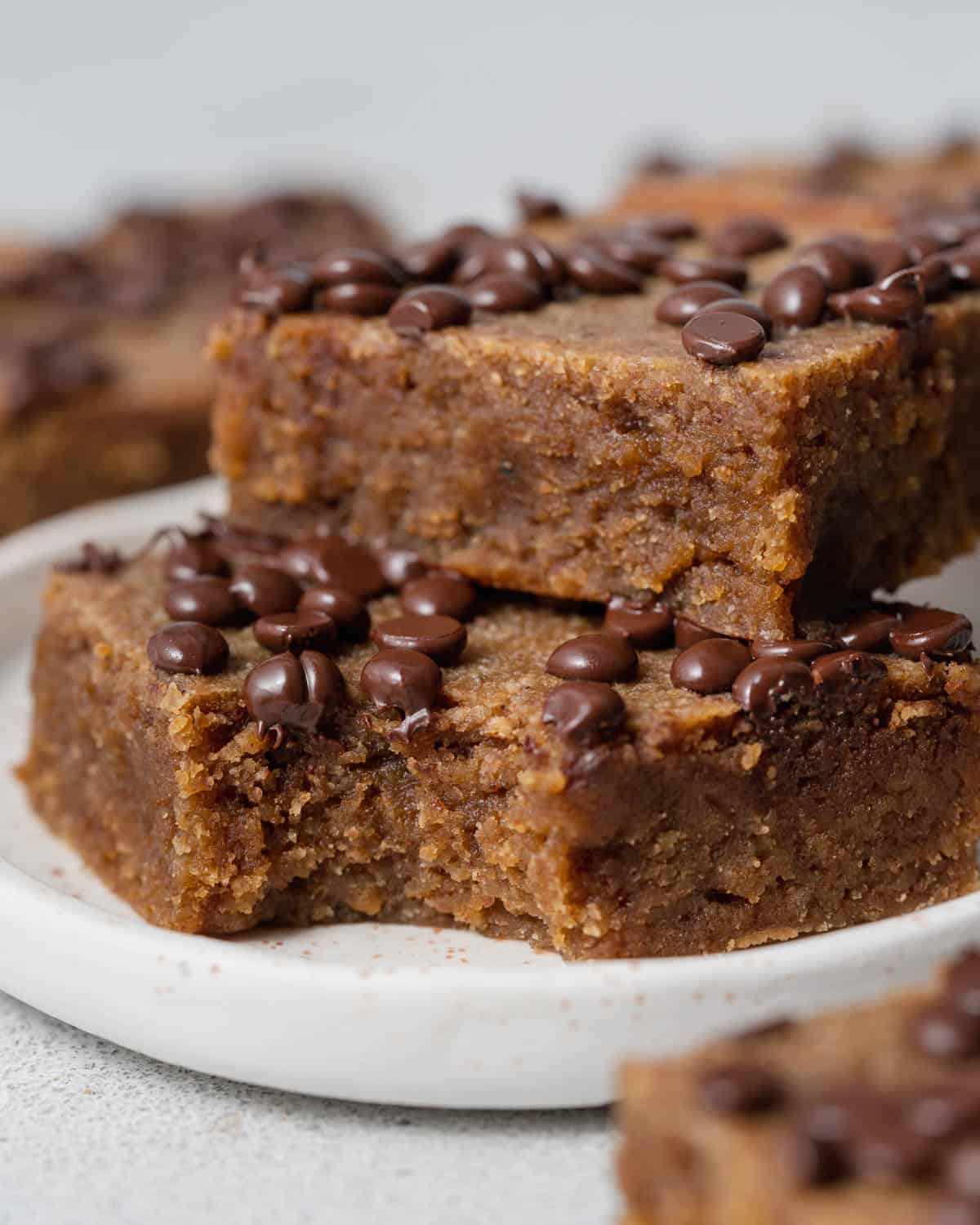 two pumpkin bars stacked over each other on a plate.