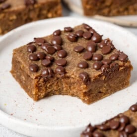 a single square pumpkin bar on a plate topped with chocolate chips.