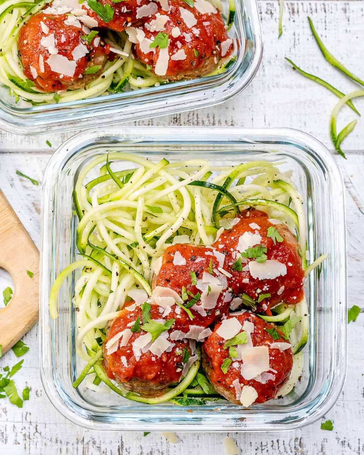 A meal prep bowl with zoodles and turkey meatballs served with marinara sauce.