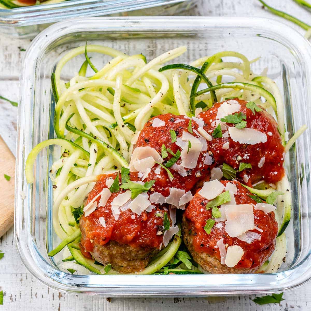 meal prep bowl with marinara sauce turkey meatballs over zoodles.