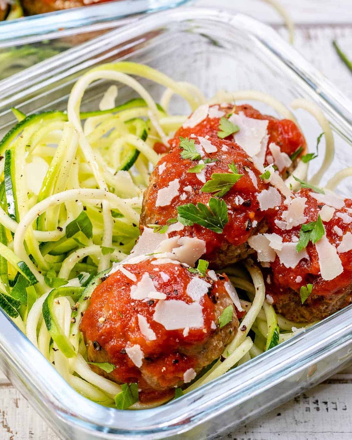 turkey meatballs served over a meal prep bowl with zoodles and marinara sauce.