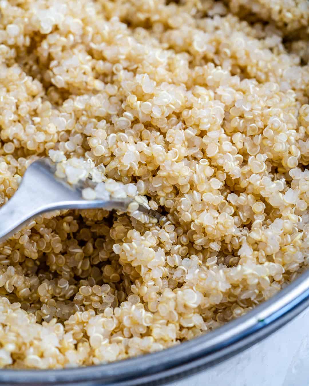 cooked quinoa in bowl with fork in it to cool off 