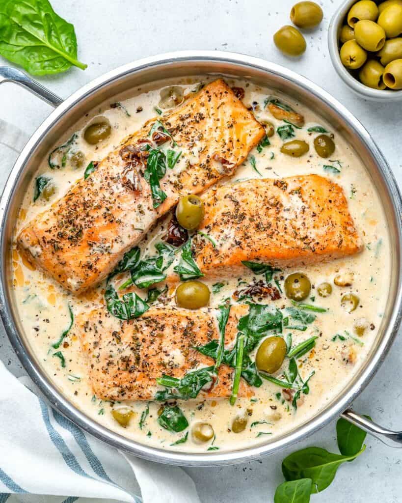 salmon filets cooked in a creamy Tuscan sauce in a pan
