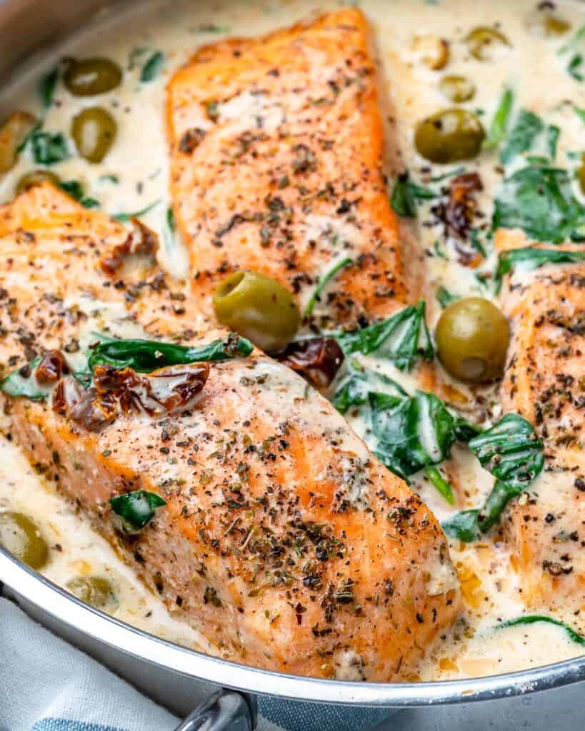 close up top down shot of Tuscan salmon in a creamy sauce in skillet