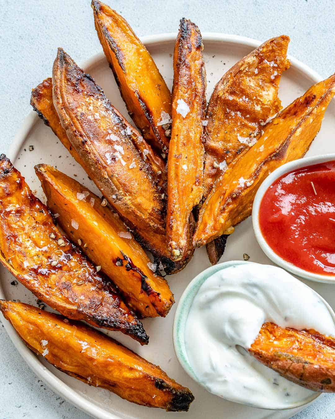 one sweet potato wedge in a small bowl of ranch dip