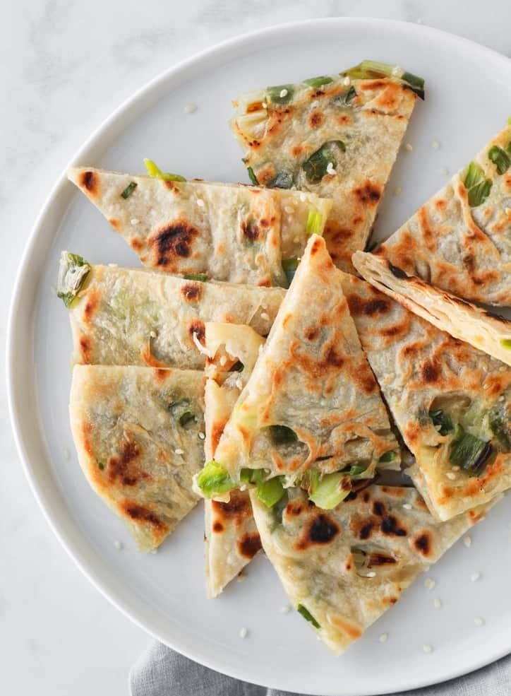 top view of cut up scallion pancakes on a plate