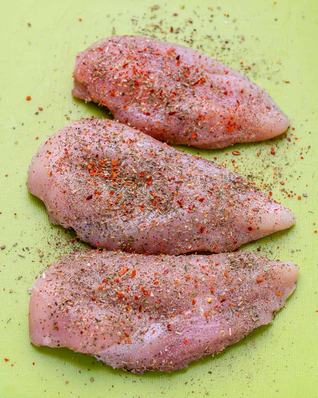 raw chicken breasts with seasoning