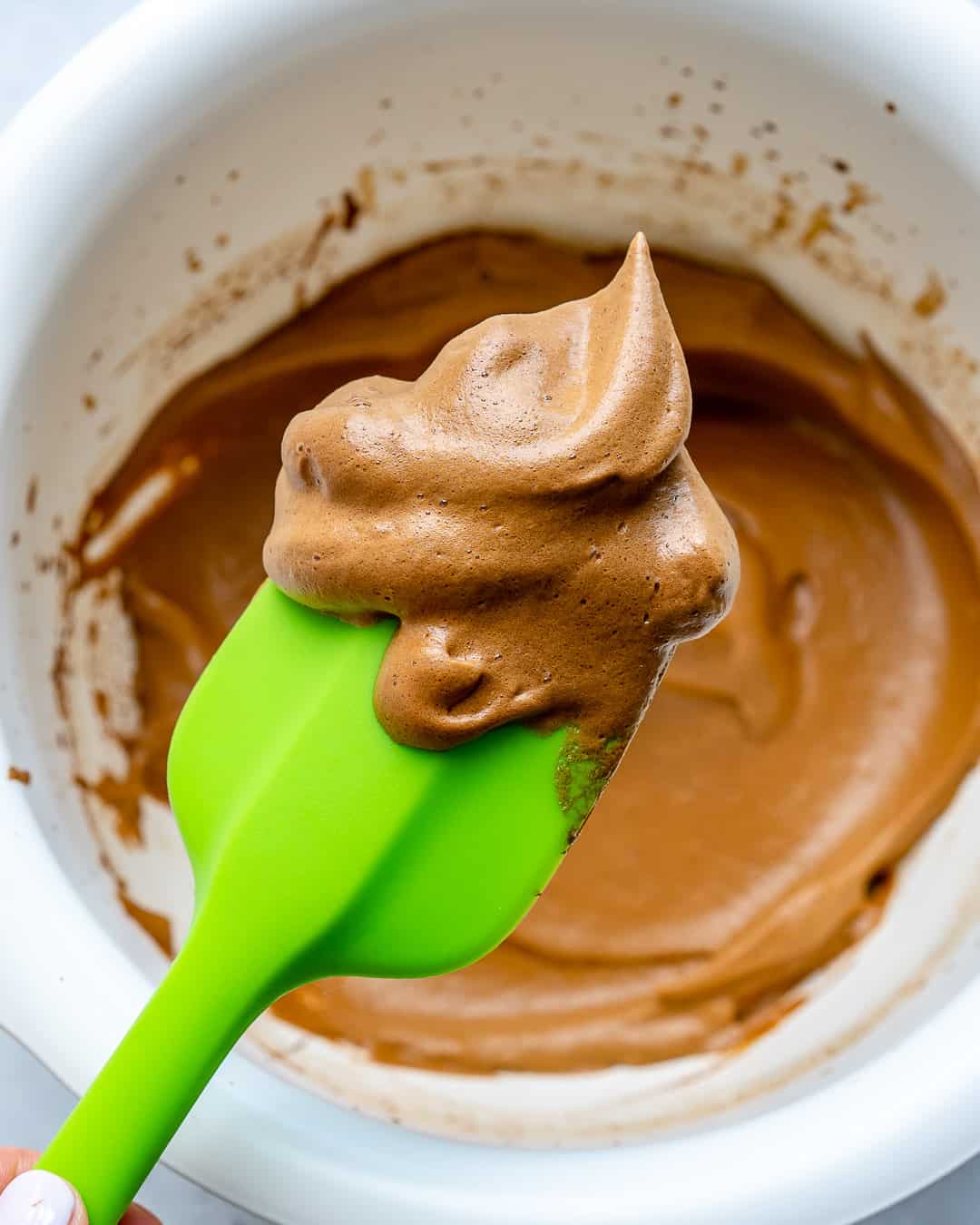 green spatula holding up whipped coffee