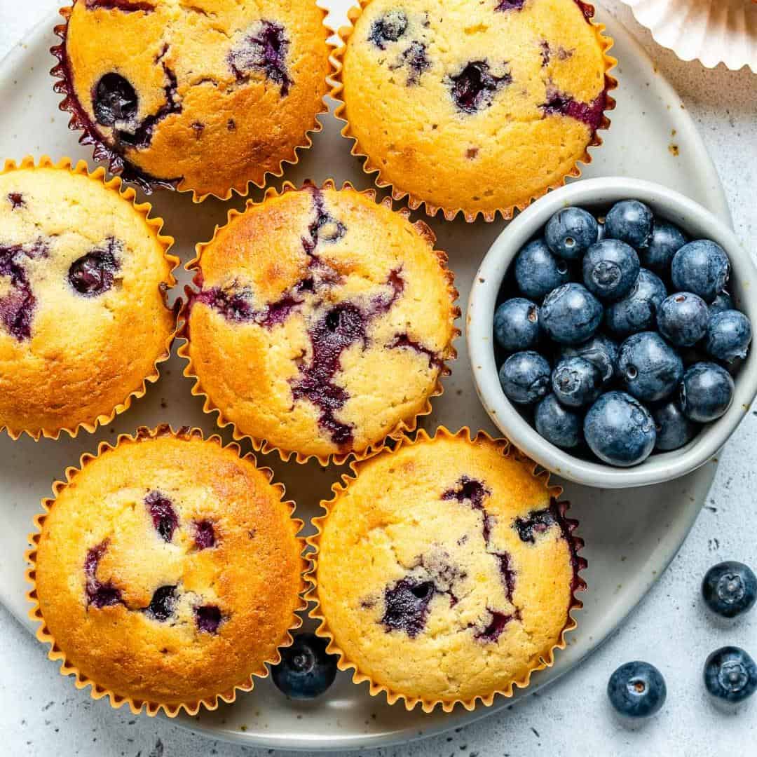 top view of muffins with side of fresh blueberries in a bowl