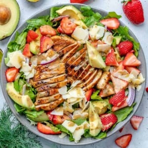 top view salad bowl with grilled chicken, strawberries, avocado, and cheese