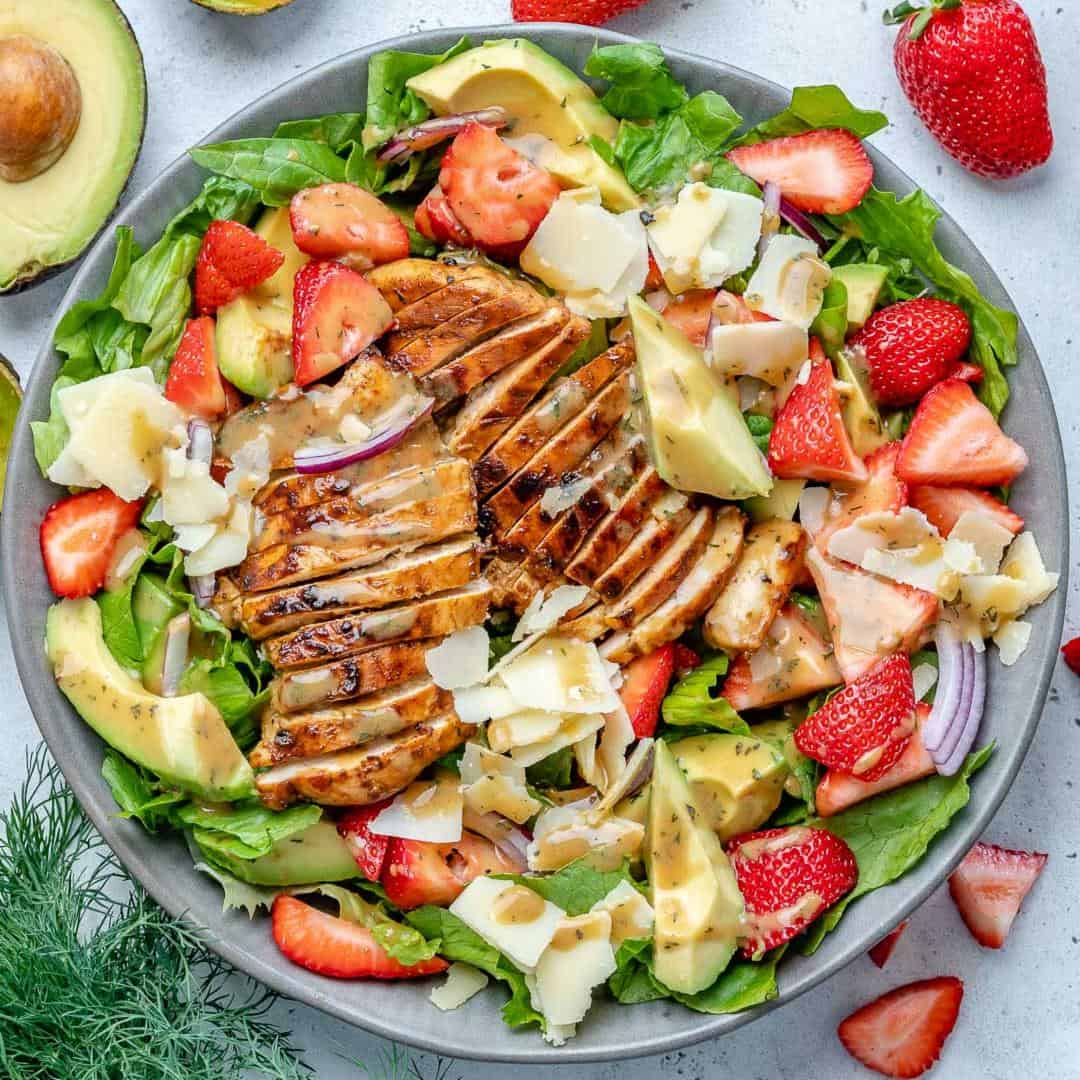 top view salad bowl with grilled chicken, strawberries, avocado, and cheese